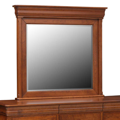 Cherry dresser mirror with beveled glass and a crown-molded frame resting on the triple dresser top