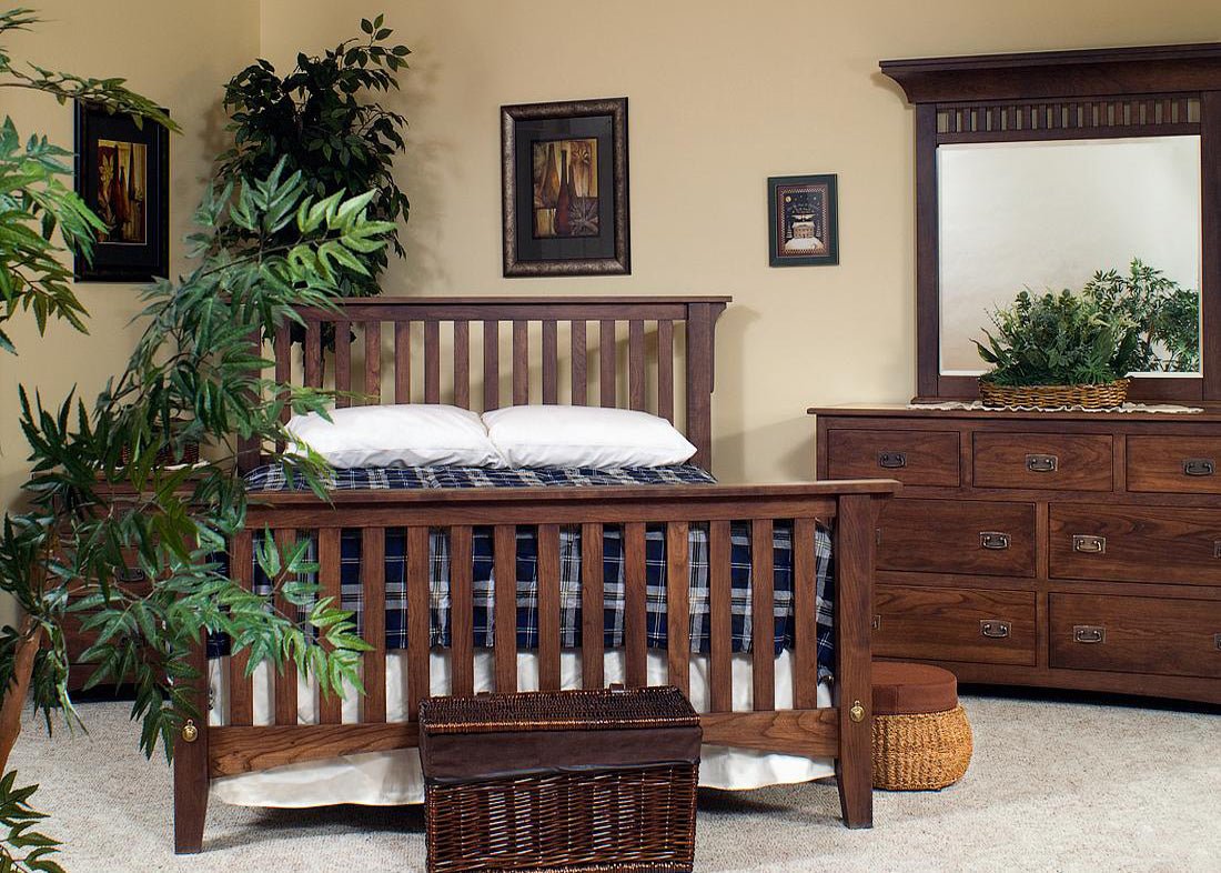 Slatted Mission bed in dark stained wood with matching dresser and mirror, styled with plants in a bedroom