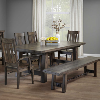 Gray Ouray iron buckle trestle table with plank top and bench, slat back chairs and cotton stems in a dining room