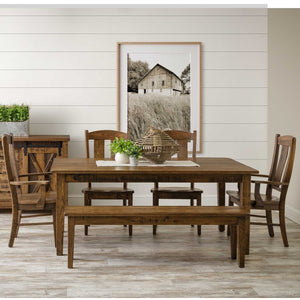 Rustic oak extendable leg dining table with matching bench, chairs and barn door sideboard beneath a framed barn photo