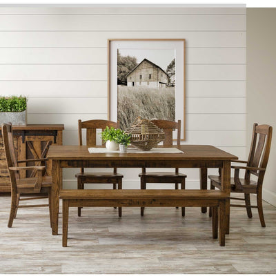 Rustic oak extendable leg dining table with matching bench, chairs and barn door sideboard beneath a framed barn photo
