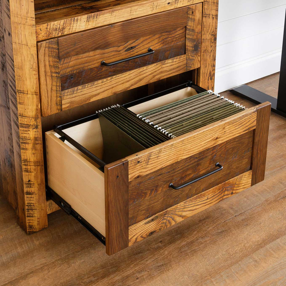 Lower file drawer pulled open on a barnwood cabinet, showing hanging folders in a maple-lined drawer box