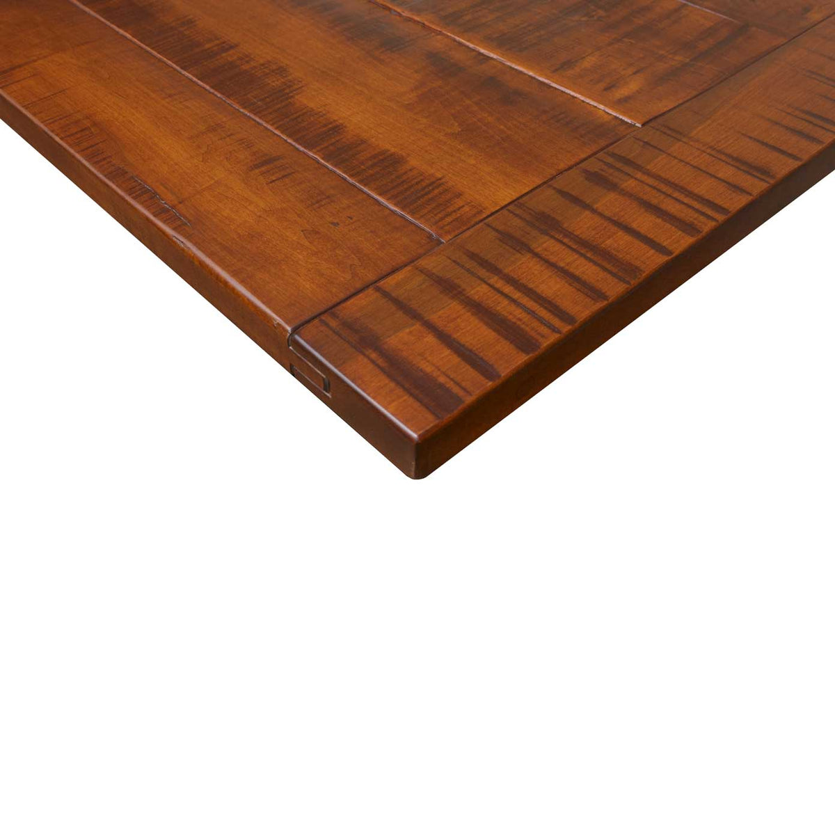Close-up corner of the 36" x 78" kitchen island top: rough sawn amber plank surface with a breadboard end seam and thick edge