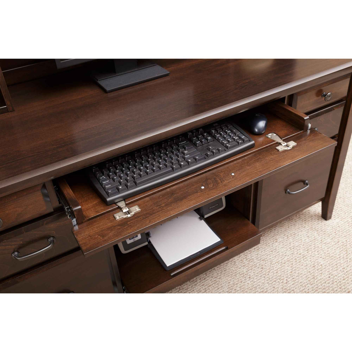 Keyboard tray extended from the walnut credenza above an open printer shelf holding a laptop