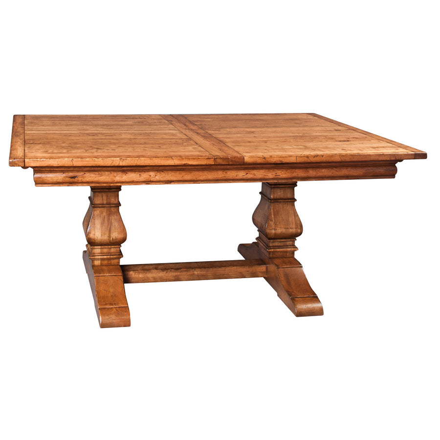 Honey toned trestle dining table with a plank top, two turned urn pedestals and a shaped stretcher base