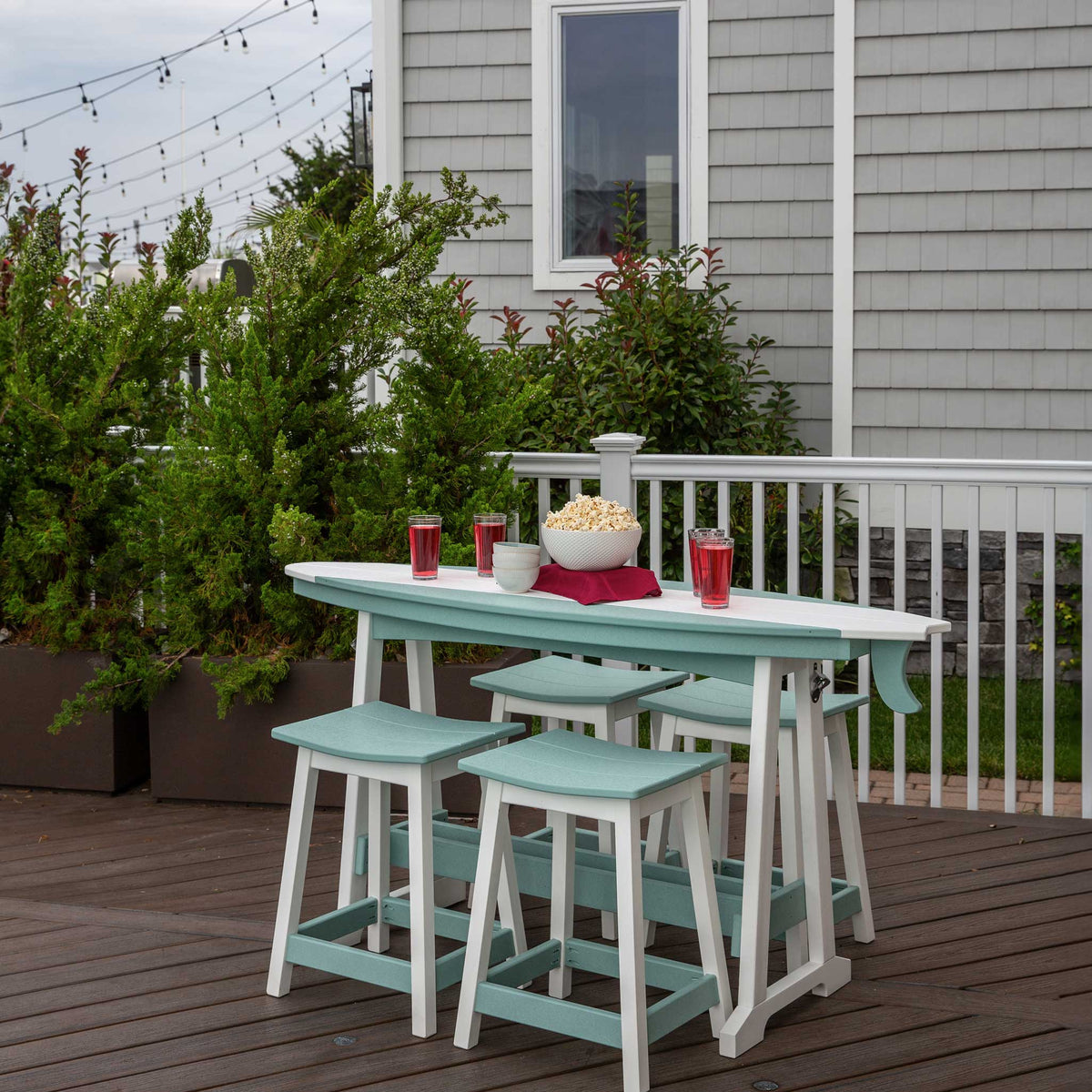 Outdoor patio set with table and stools on a wooden deck.