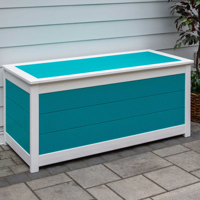 Turquoise and white five foot poly cushion storage box with plank lid on a paver patio by white siding
