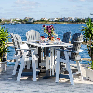 Gray and white poly counter height patio table with six tall Adirondack chairs set on a bayfront dock