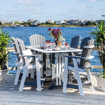 Gray and white poly counter height patio table with six tall Adirondack chairs set on a bayfront dock