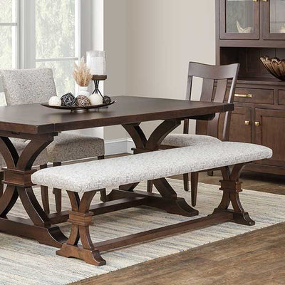 Cushioned dining bench with a gray patterned fabric seat on a dark walnut trestle base, paired with a matching dining table