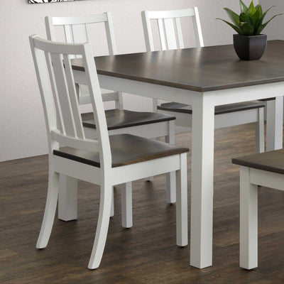 White painted dining side chairs with three back slats and gray stained seats at a two-tone plank table