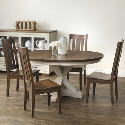 Round expandable pedestal table with dark oak plank top and white X pedestal base, surrounded by slat back chairs