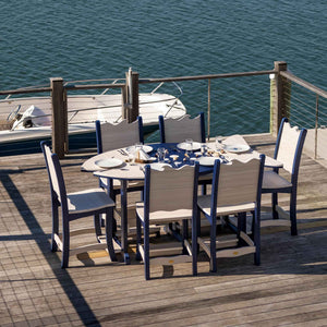 Navy and driftwood poly counter height dining table with six matching chairs set for a meal on a dock