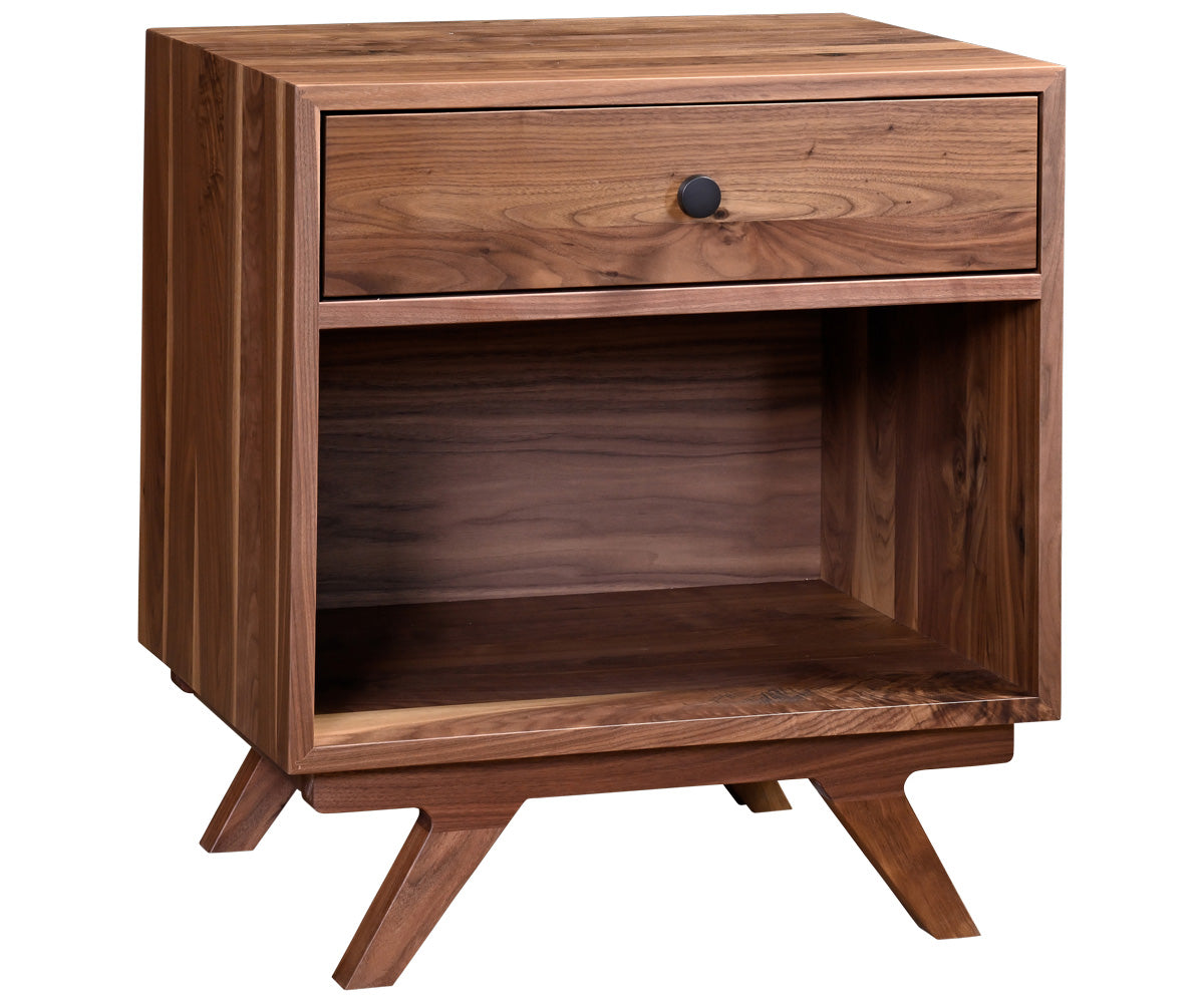 Wooden nightstand with books and decorative items next to a bed with white bedding.