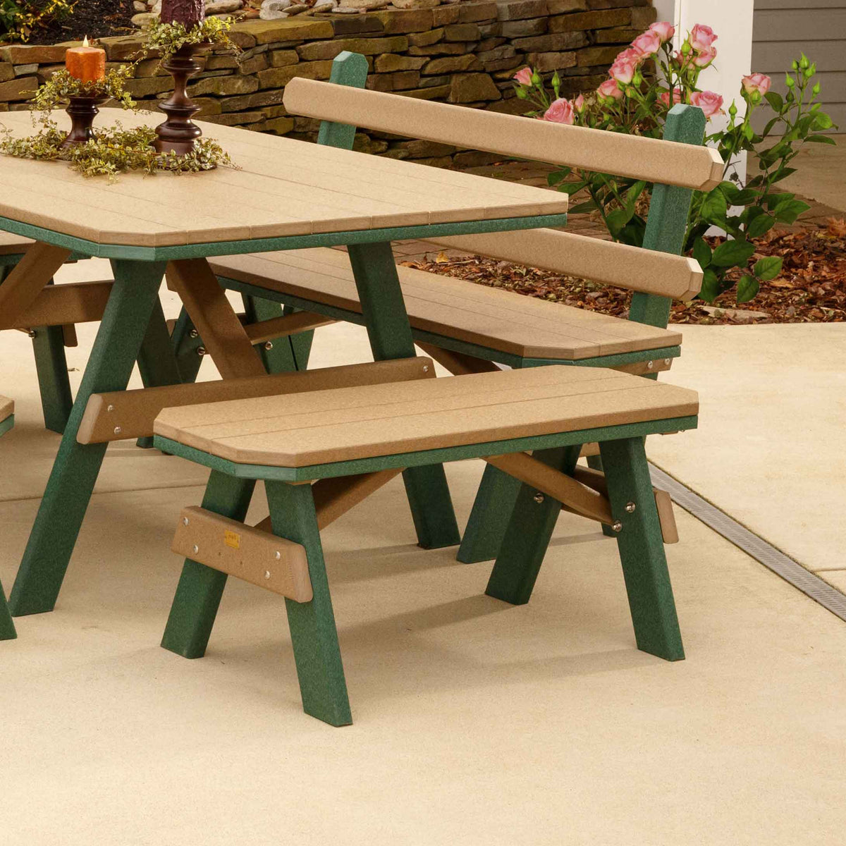 Cedar and green poly garden benches paired with a matching picnic table on a concrete patio by rose bushes