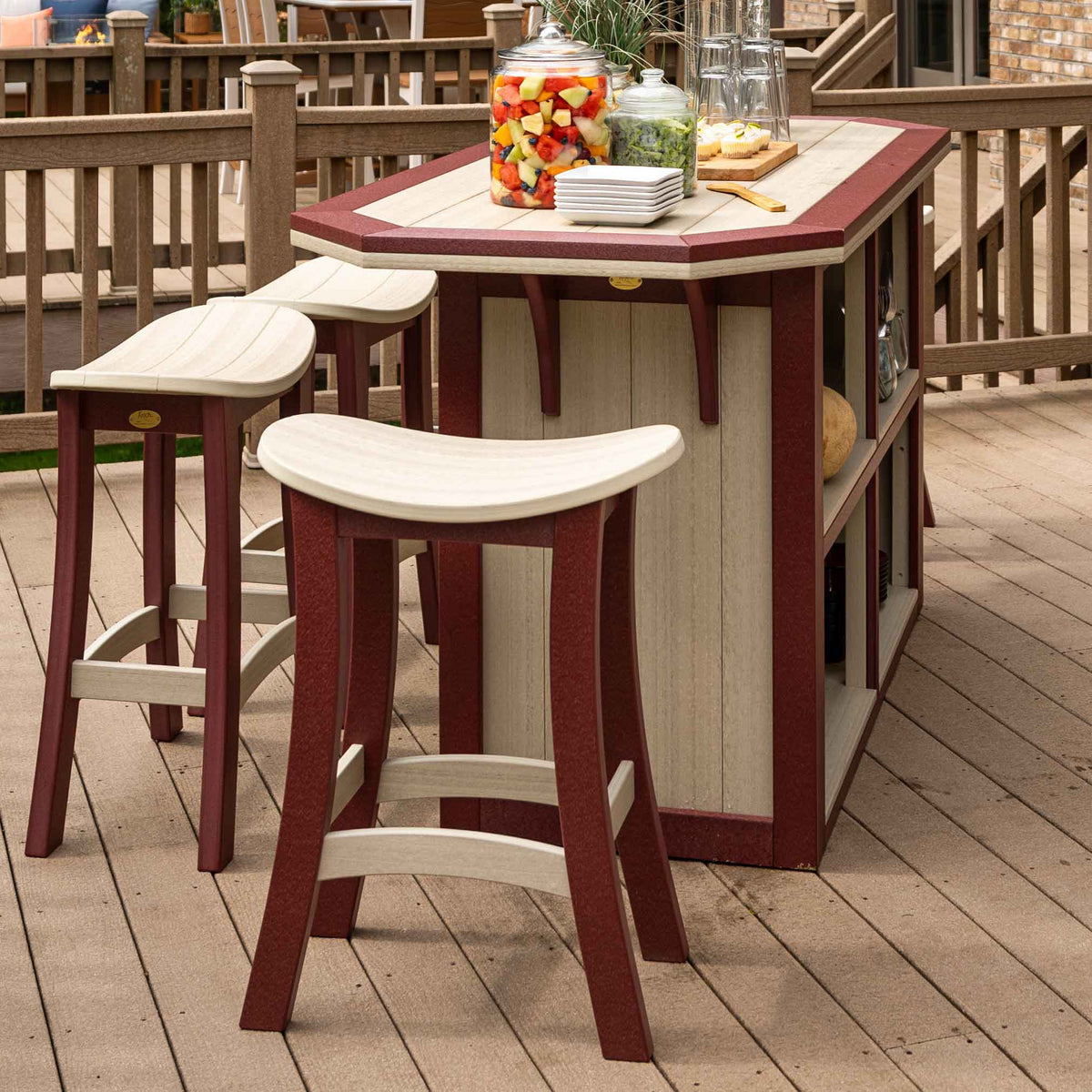 Three weatherwood and cherry saddle bar stools pulled up to a matching poly outdoor bar island on a backyard deck