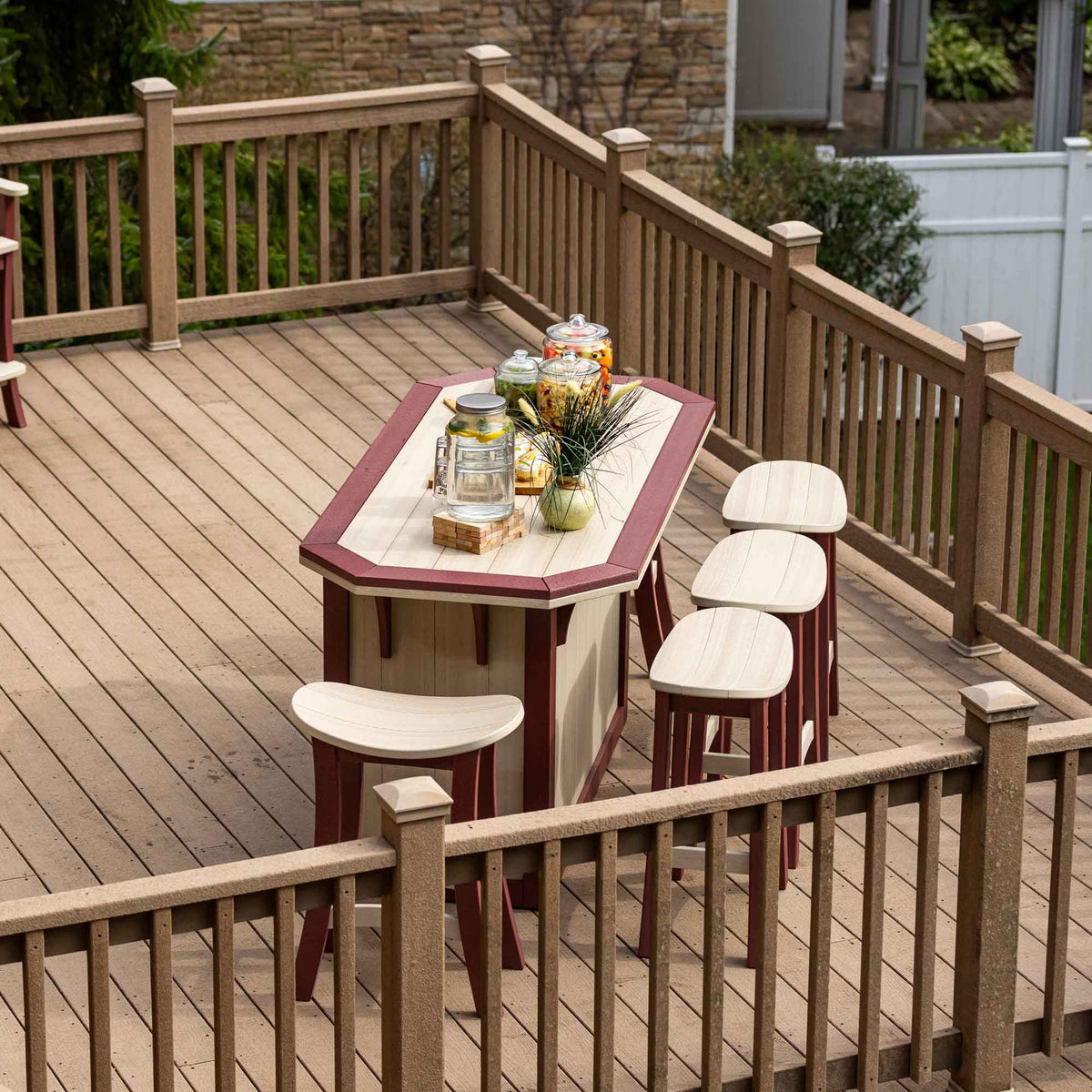 Overhead view of the birch and cherrywood poly bar island with three saddle stools on a large composite deck