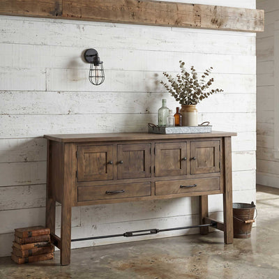 Weathered brown four-door sideboard with two drawers, iron knobs and turnbuckle stretcher against a whitewashed plank wall