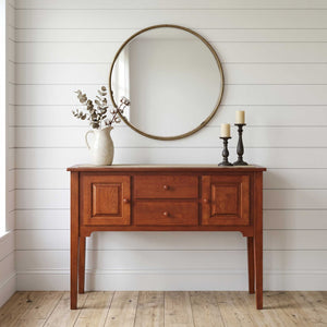 Cherry Shaker sideboard buffet with two raised panel doors, two center drawers and tall tapered legs beneath a round mirror