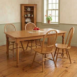Oak turned leg dining table with sheaf back chairs in a farmhouse dining room with a corner cupboard