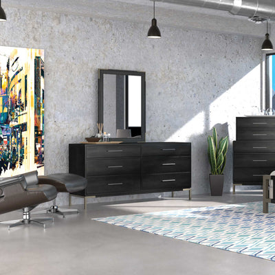 Industrial loft bedroom with a black six-drawer dresser, wall mirror, tall chest and colorful city artwork