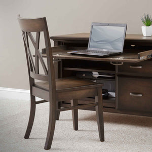 Wood office side chair with a double X back and saddle seat, pulled up to a credenza with a laptop