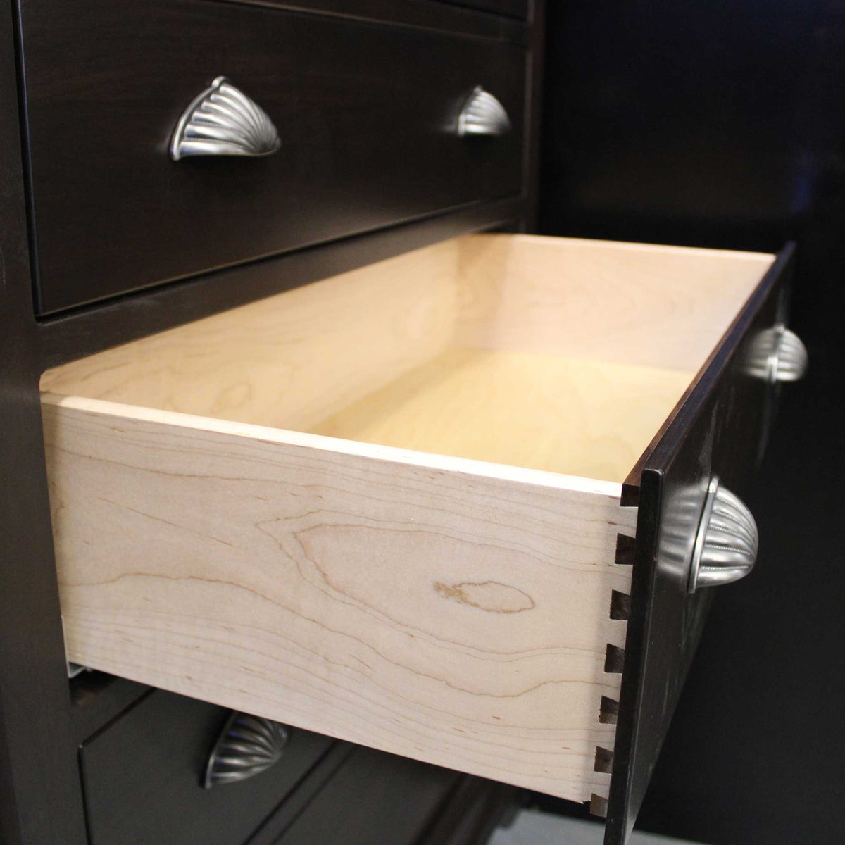 Extended maple drawer with dovetail joinery in a dark espresso chest, fitted with shell-shaped satin nickel cup pulls