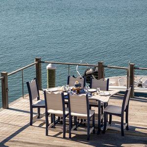 Navy and tan poly fish shaped dining table set for six overlooking the water from a boat dock