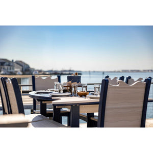 Poly patio dining chairs with wave shaped backs pulled up to a navy and tan table at a waterfront deck