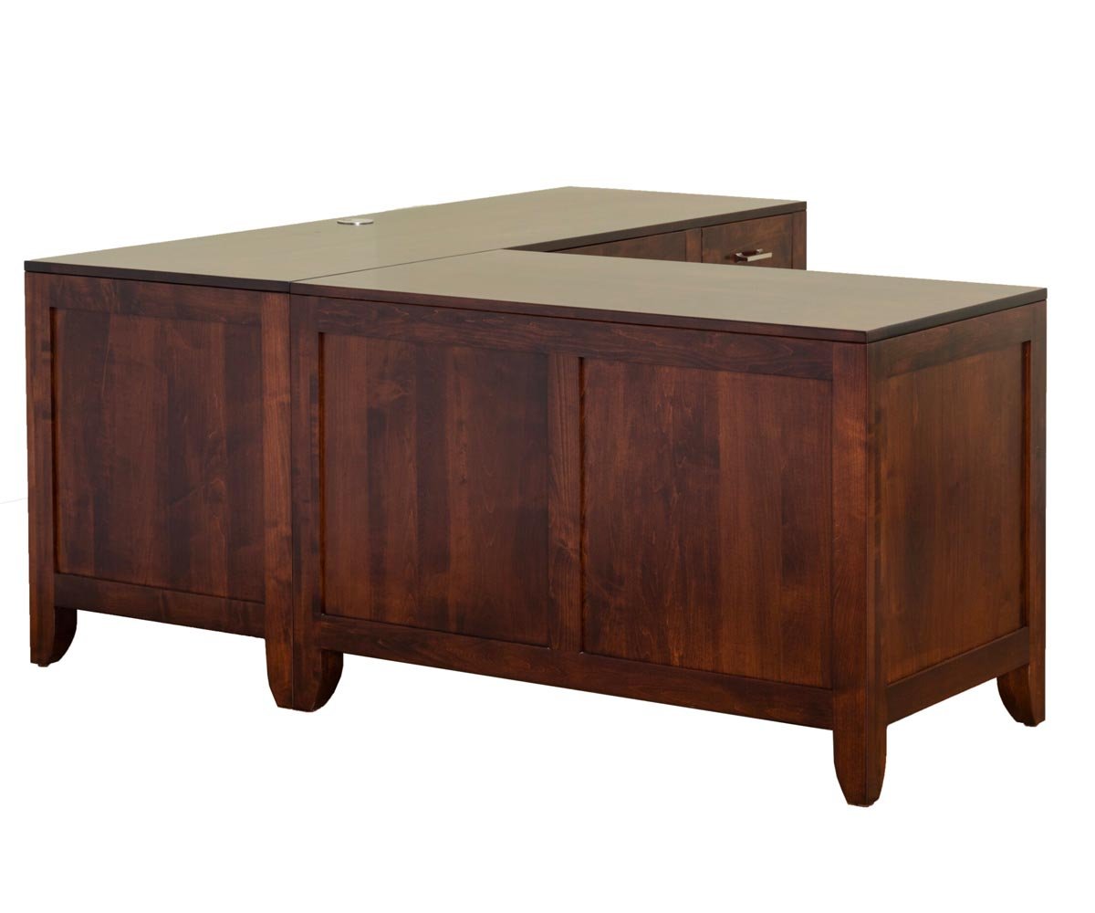Back view of a cherry L shaped desk showing finished panel backs, tapered legs and a wire access notch in the return top
