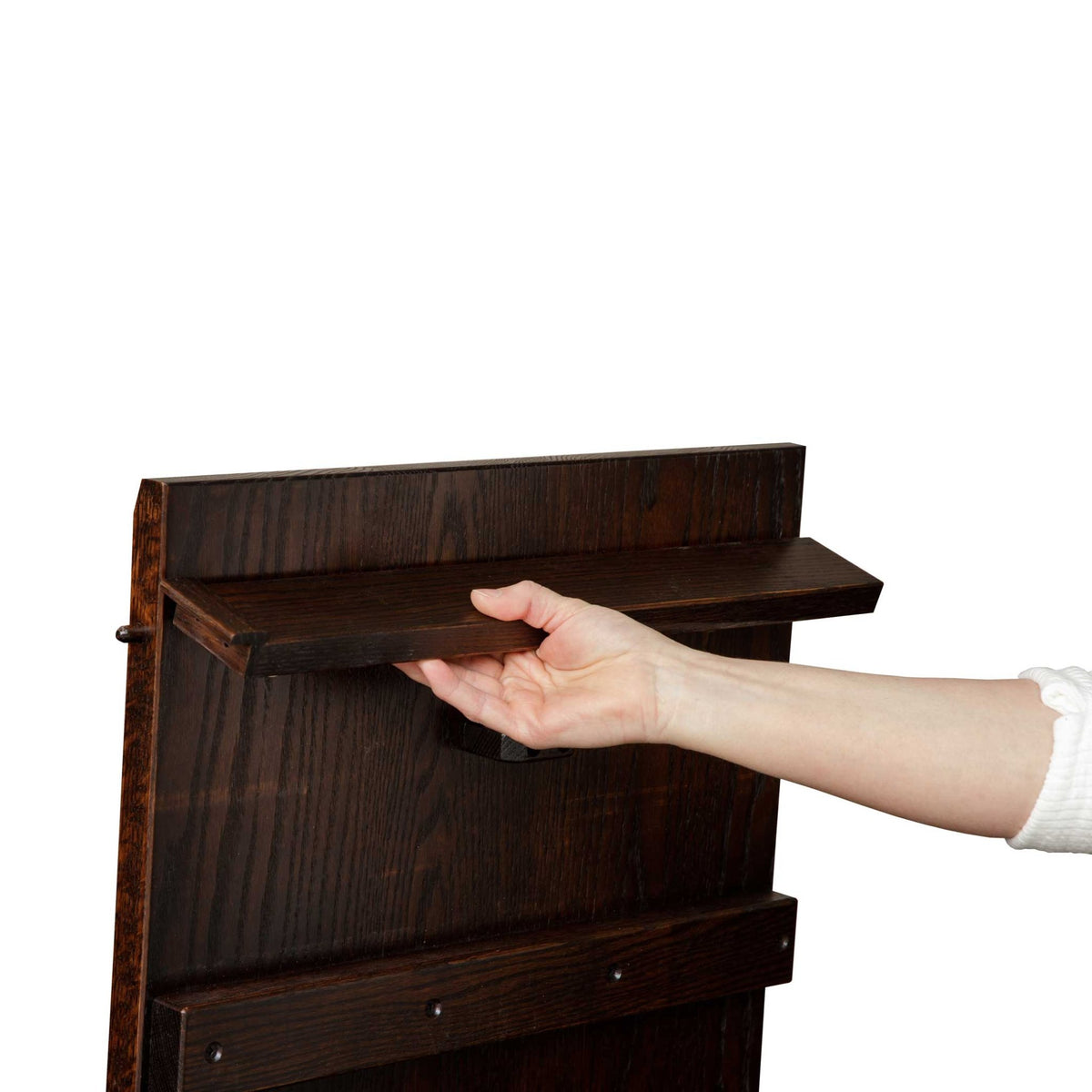 Hand pulling out the wooden butterfly leaf support bracket on the underside of the Christy dining table