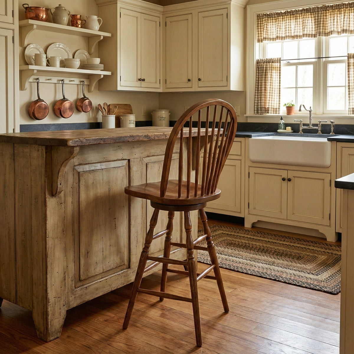 Oak Windsor swivel bar stool with nine spindles and turned legs pulled up to a rustic wood kitchen island in a country kitchen