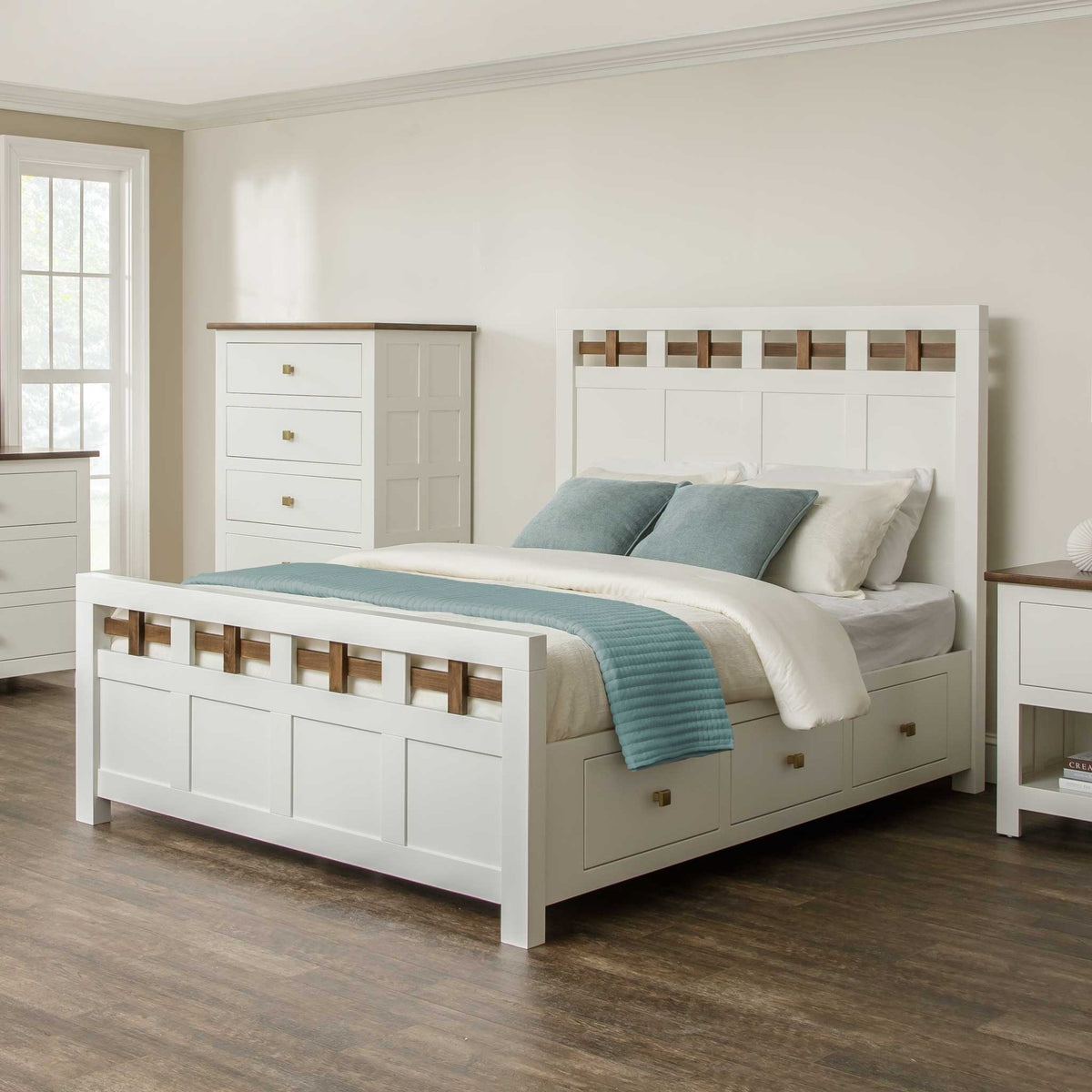 White storage bed with lattice headboard, brown accents and three footboard drawers with brass knobs in a bedroom