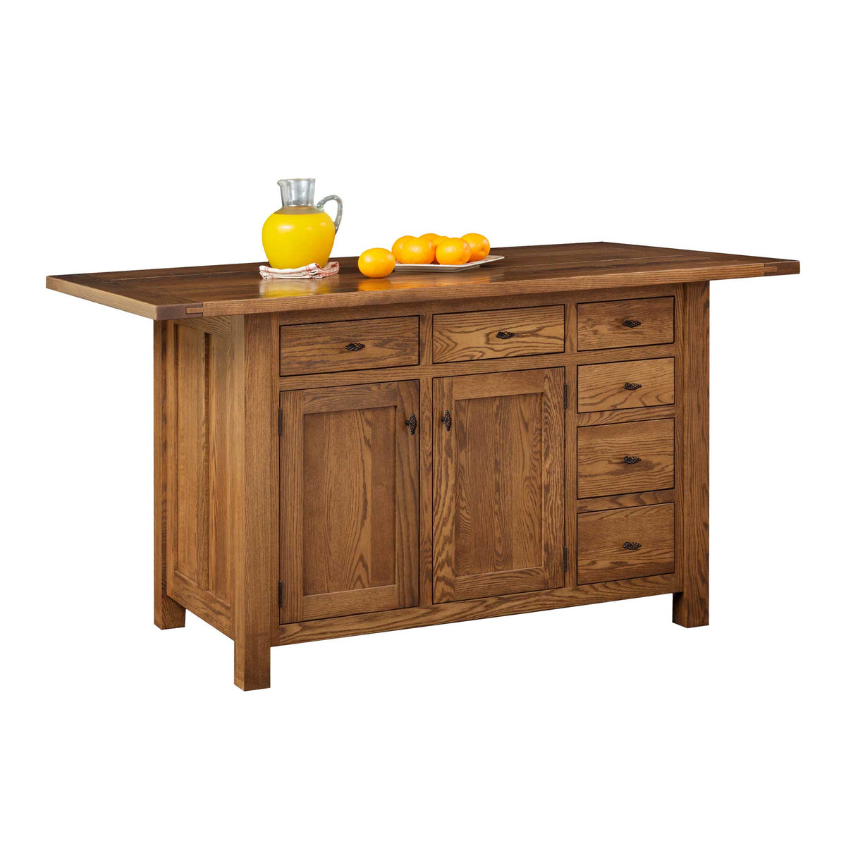 Oak kitchen island with six drawers, two cabinet doors and an overhanging drop leaf top holding lemons and juice