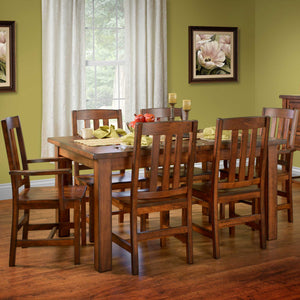 Rustic cherry leg dining table with six slat-back chairs set for a meal in a green dining room