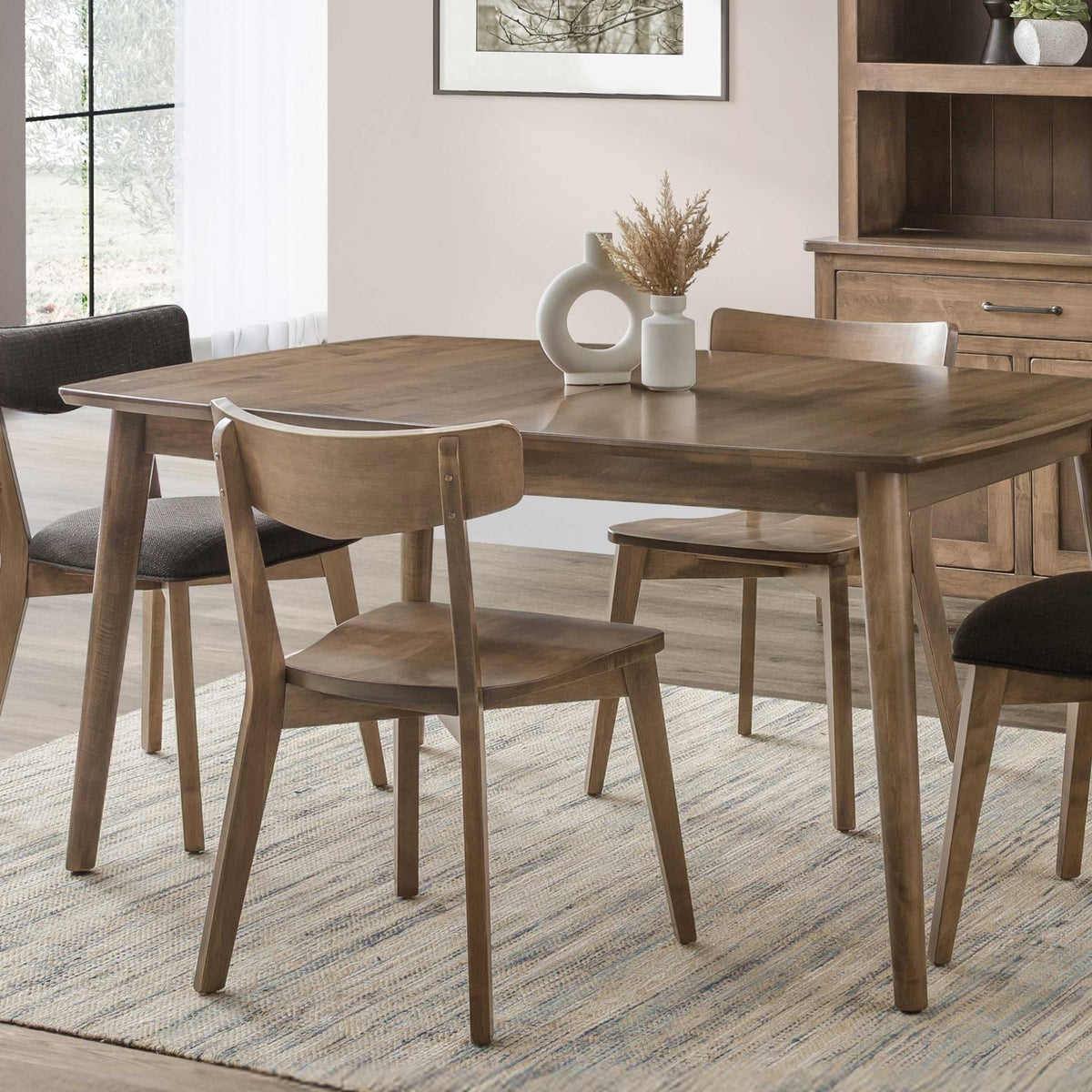 Mid century modern dining chairs with curved back rests and wood seats around a light walnut dining table