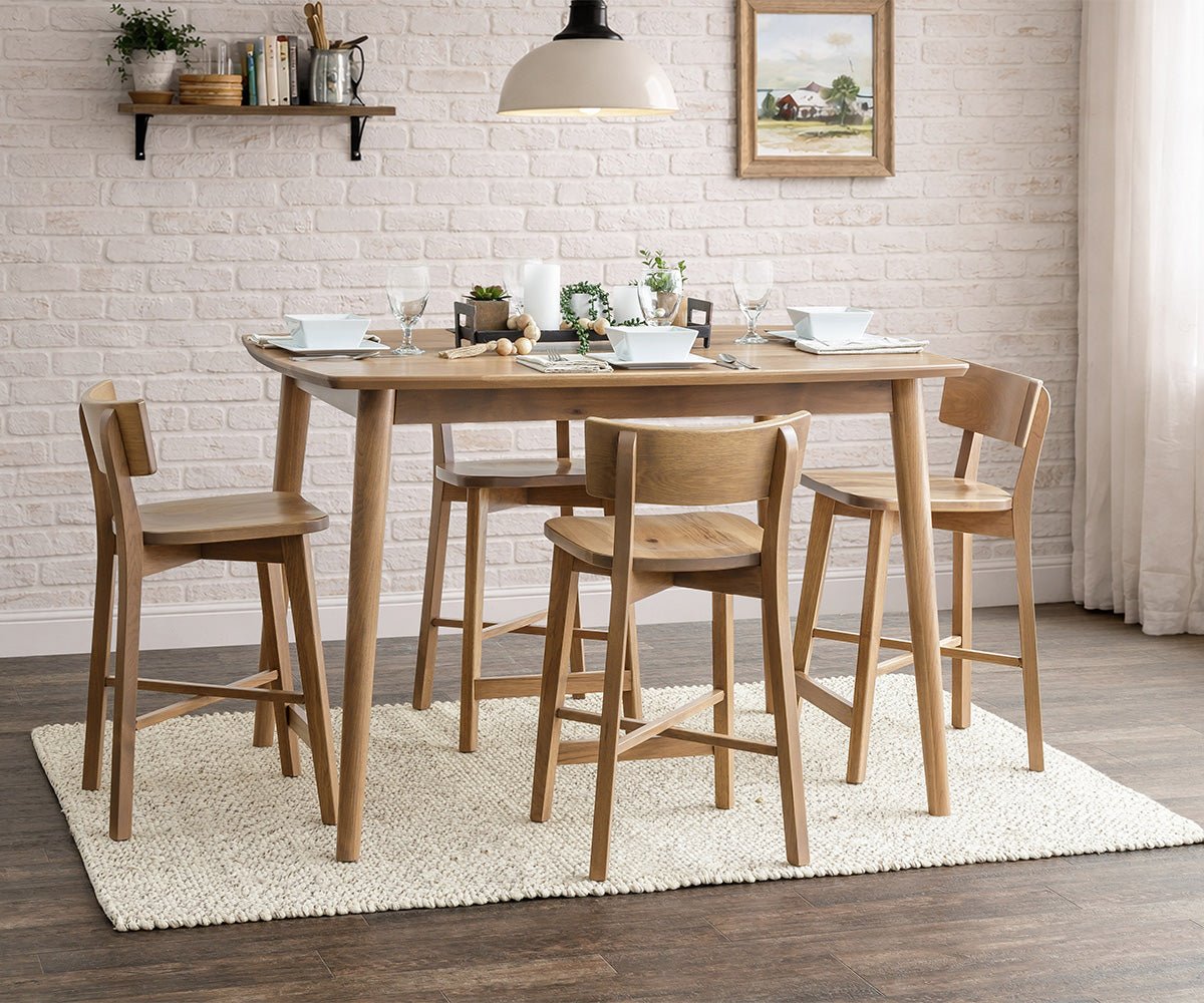 White brick dining nook with a light oak counter height table, four curved-back stools and place settings