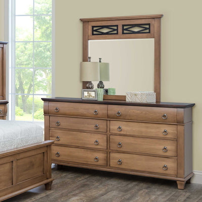 Light almond triple dresser with dark top and a lattice topped mirror styled with lamps in a sunlit bedroom