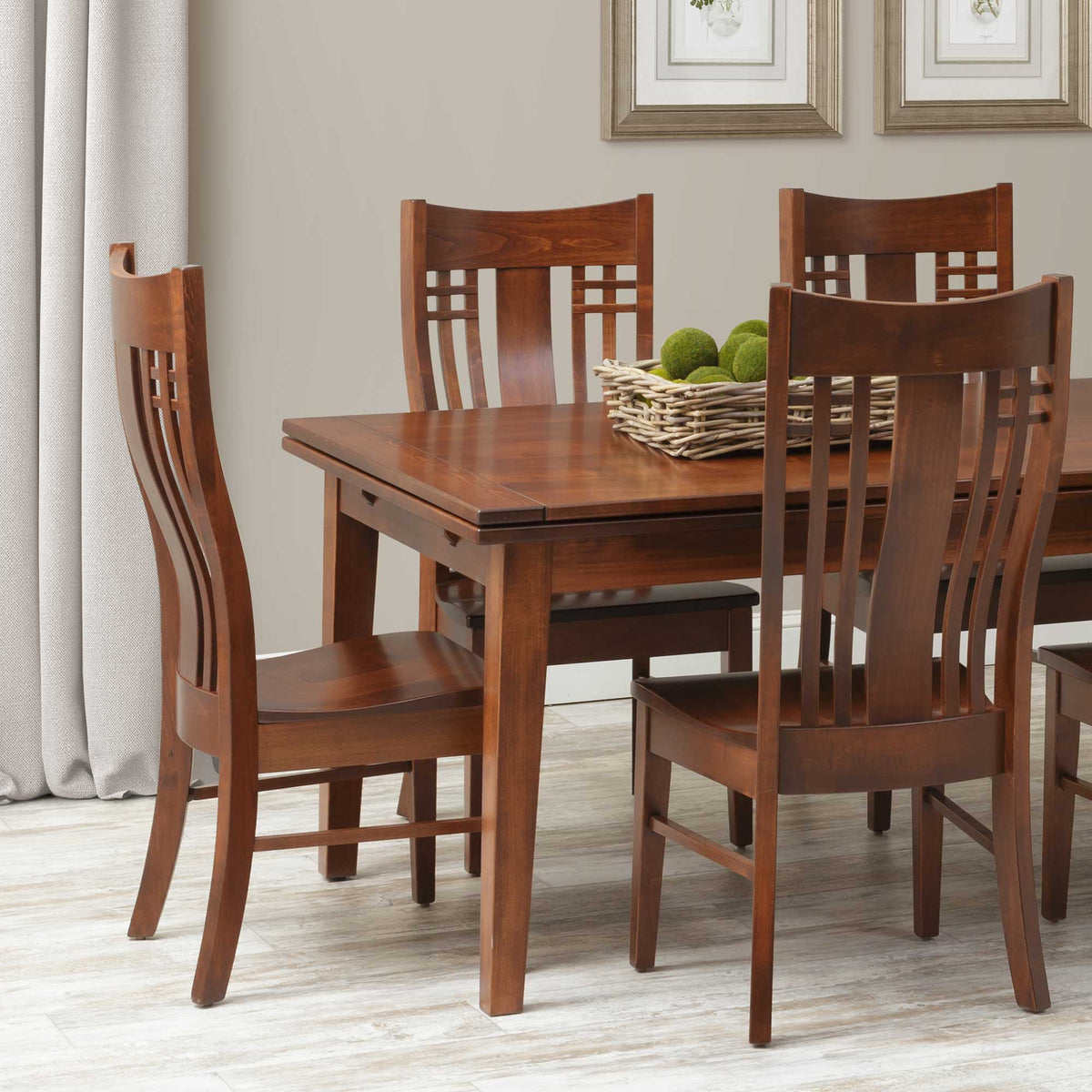 Mission style dining chairs with lattice accented lumbar backs around a cherry leg table holding moss balls