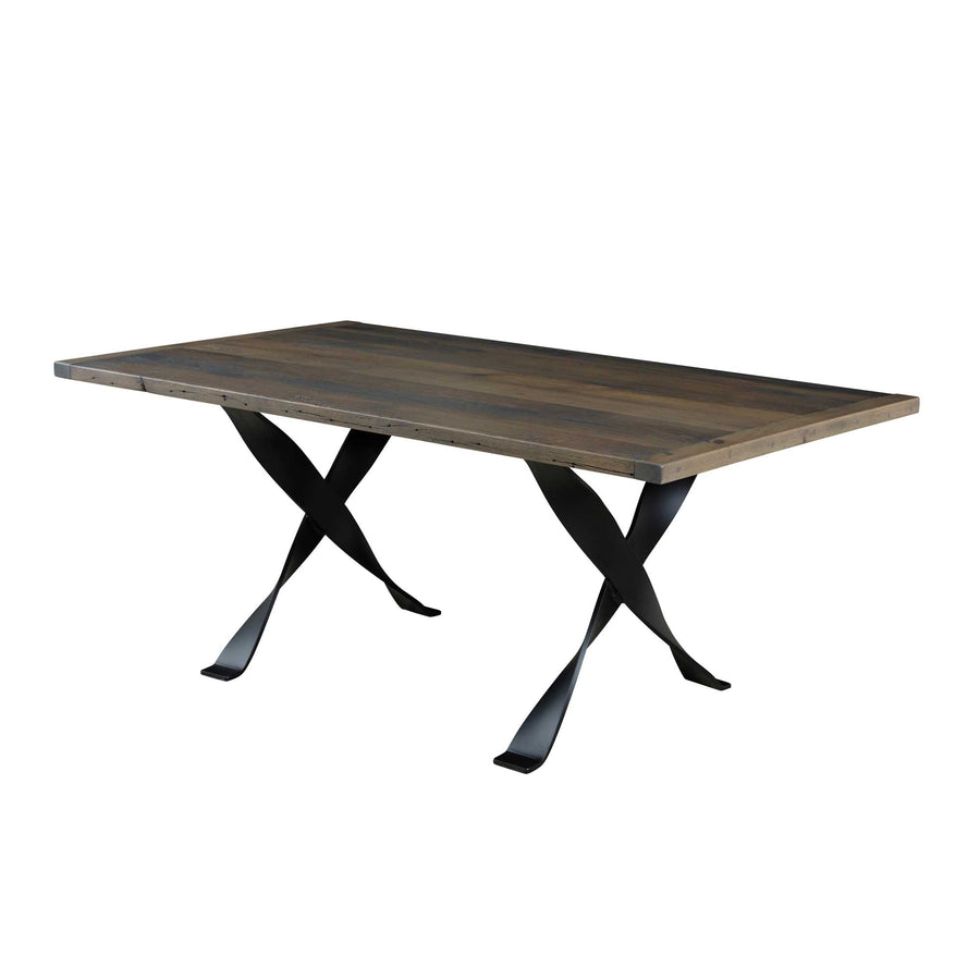 Weathered gray reclaimed wood dining table with a plank top on twisted black iron X shaped trestle legs