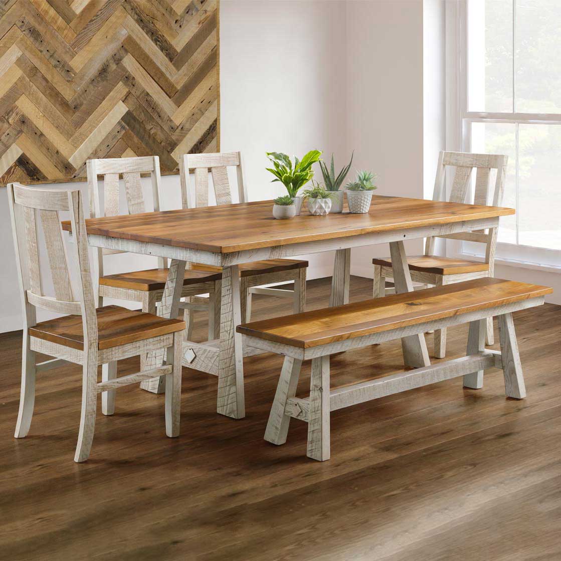 Whitewashed trestle dining set with a honey stained top, four panel back chairs and a bench in a herringbone wall room