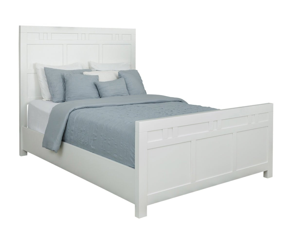 Angled view of a white painted queen panel bed with block-inlay headboard, matching paneled footboard and blue-gray quilt