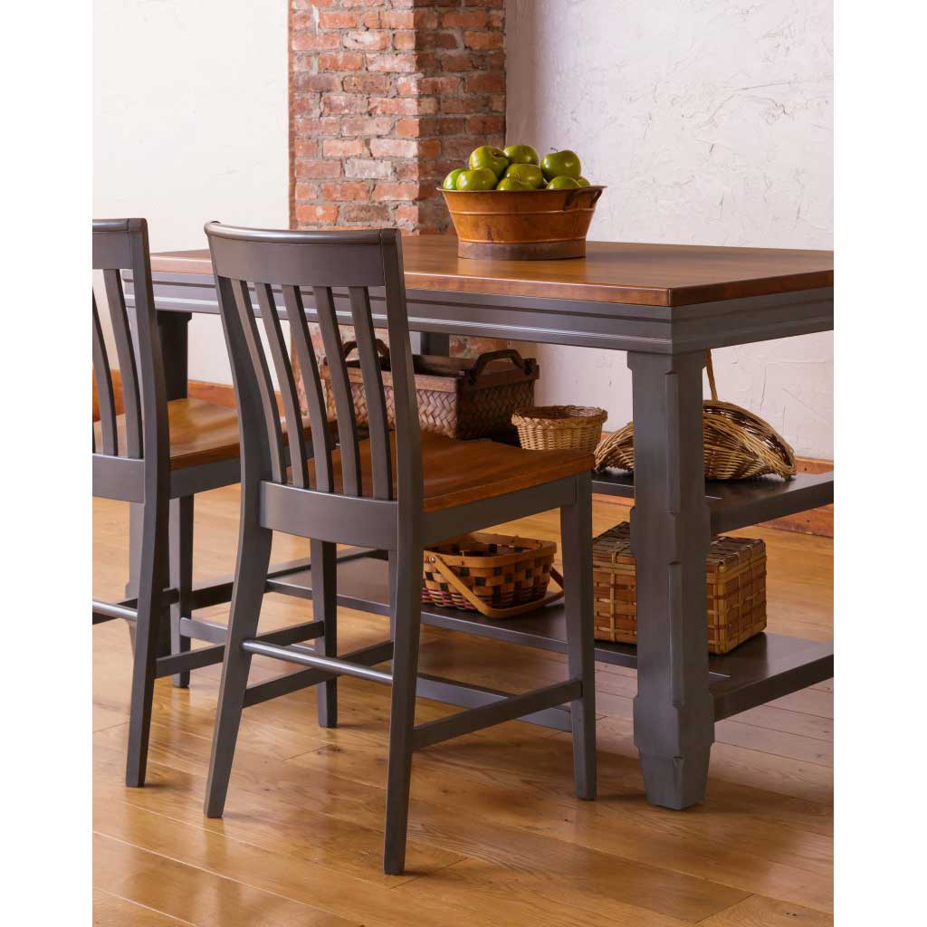Gray painted slat back counter stools with saddle wood seats at a two tone kitchen counter height table