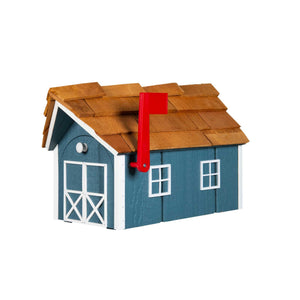 Slate blue wood barn mailbox with cedar shake roof, white cross-braced doors and knob, red flag raised