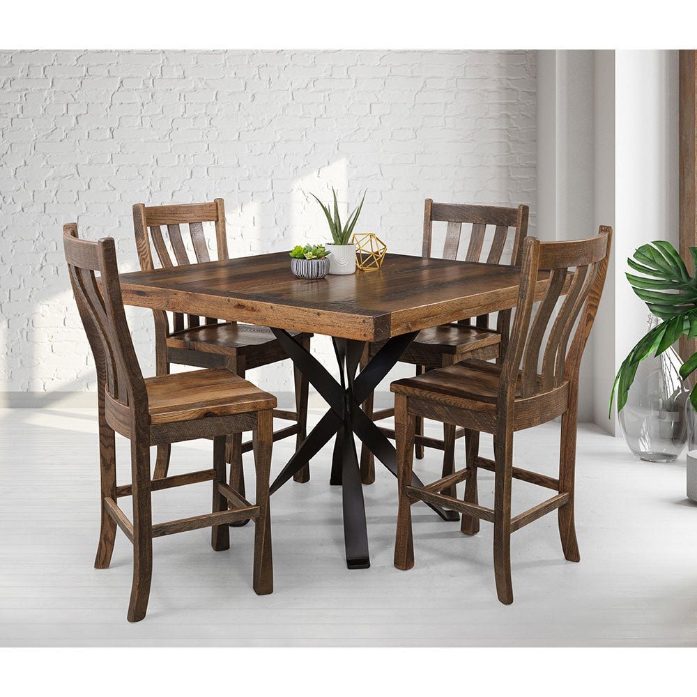 Reclaimed wood counter table set with four slat back stools staged against a white brick wall with plants
