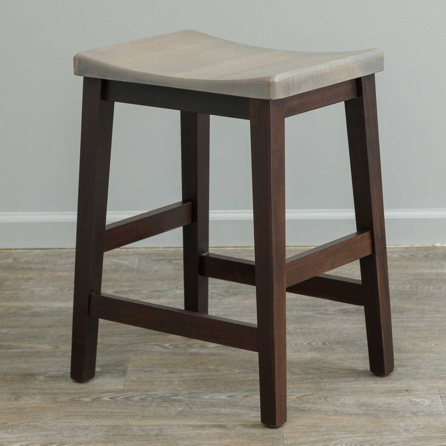 Two-tone counter stool with a driftwood gray saddle seat and dark brown legs with H stretcher footrests