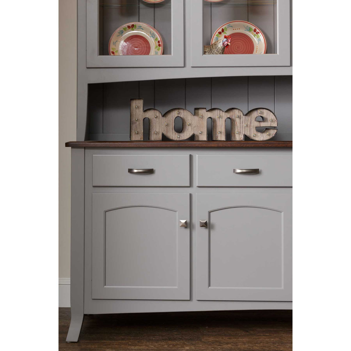 Lower cabinet detail of the gray hutch with a walnut server top, two drawers and arched panel doors