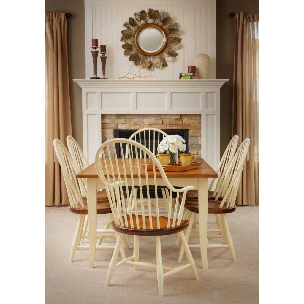 Two tone dining set with cream painted bow back Windsor chairs and a cherry topped table by a stone fireplace