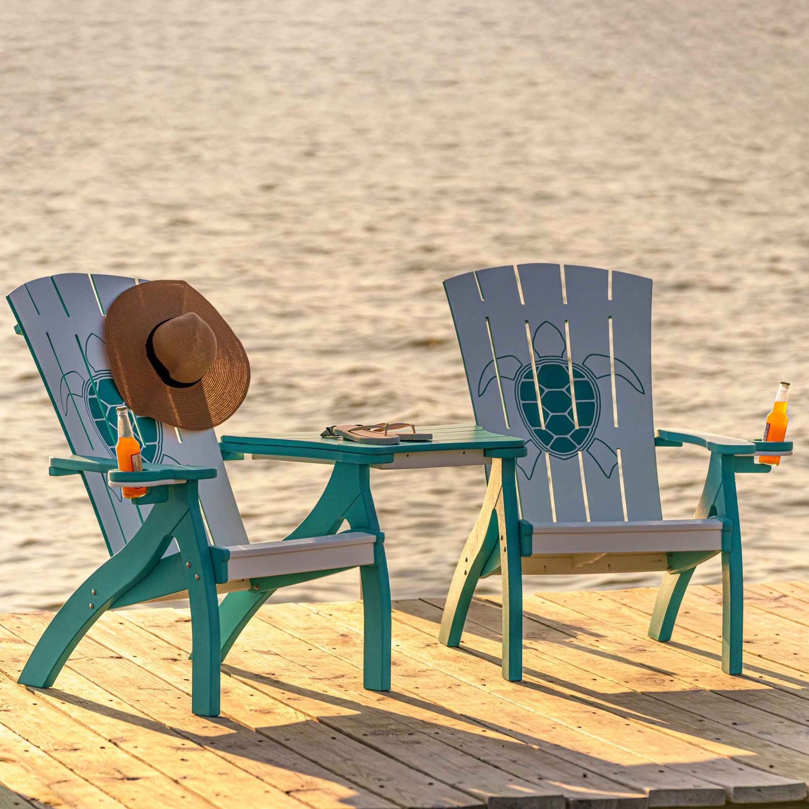 Couple relaxing in white and turquoise poly Adirondack chairs joined by a center table on a lakeside dock
