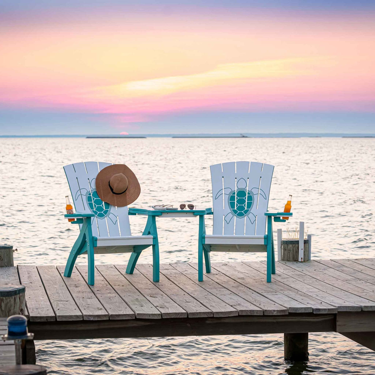 Back view of two turtle back Adirondack chairs and connecting table on a dock at sunset